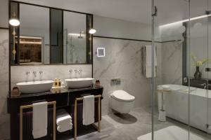 bagno con 2 lavandini, servizi igienici e vasca di The Biltmore Mayfair a Londra