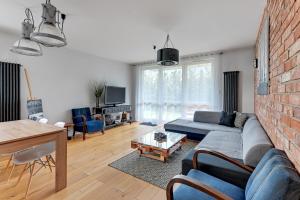 a living room with a couch and a brick wall at Platinium Kartuska Modern in Gdańsk