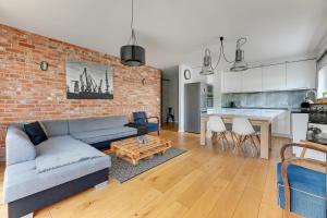 a living room with a couch and a brick wall at Platinium Kartuska Modern in Gdańsk