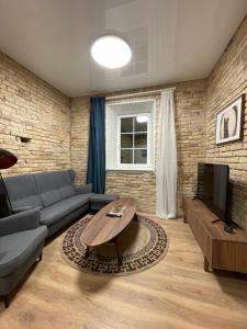 ein Wohnzimmer mit einem Sofa und einem TV in der Unterkunft Authentic Old Town Spot in Vilnius