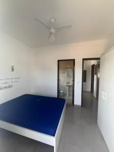 Schlafzimmer mit einem blauen Bett und einem Deckenventilator in der Unterkunft Apartamento Ubatuba, Itaguá, Príncipe dos Poetas in Ubatuba + 1 Foto