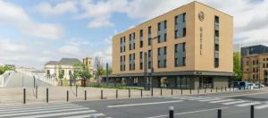 un edificio con un reloj al lado de una calle en B&B HOTEL Thionville Centre Gare en Thionville