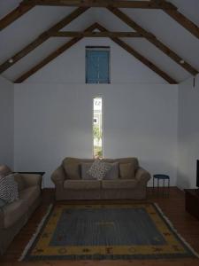 a living room with a couch and a window at Moira's Cottage in Calitzdorp