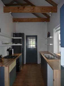 a kitchen with wooden counters and a hallway with a door at Moira's Cottage in Calitzdorp