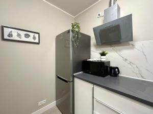 uma cozinha com um frigorífico e uma televisão na parede em MMRent Frog Room em Gdansk