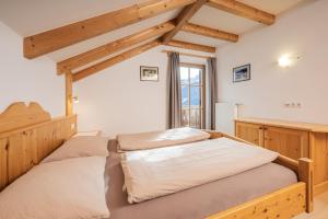 una camera con letto e testiera in legno di Klaudehof a Dobbiaco