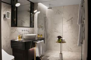 ein Bad mit einem Waschbecken und einer Dusche in der Unterkunft The Biltmore Mayfair in London