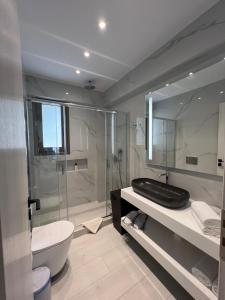 La salle de bains est pourvue d'une baignoire, d'un lavabo et de toilettes. dans l'établissement Luxury apartment, à Athènes