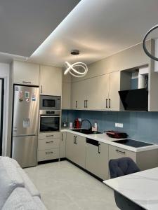 - une cuisine avec des placards blancs et un réfrigérateur en argent dans l'établissement Luxury apartment, à Athènes