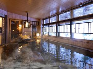 una gran piscina de agua en una habitación con ventanas en Dormy Inn Gifu Ekimae en Gifu