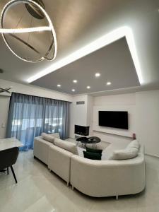 Il comprend un salon doté d'un canapé et d'une télévision à écran plat. dans l'établissement Luxury apartment, à Athènes