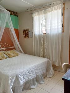 a bedroom with a white bed and a window at Villa 301 B&B in Baclayon