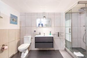 a bathroom with a toilet and a sink and a shower at GuestReady - Modern Nest near Parc André Citroën in Paris