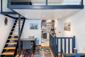 a room with a staircase with a table and a kitchen at GuestReady - Modern Nest near Parc André Citroën in Paris