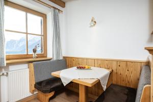 a small dining room with a table and a window at Klaudehof in Dobbiaco