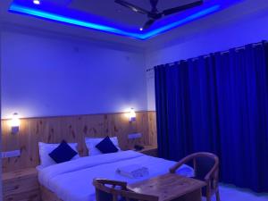 Un dormitorio con una cama con luces azules. en Bollywood Lodge, en Sahāranpur
