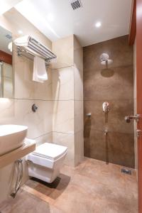 y baño con aseo, lavabo y ducha. en Hotel Supreme Comforts - International Airport, en Bombay