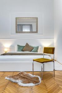 sypialnia z łóżkiem, krzesłem i lustrem w obiekcie Székely Bertalan Residence w Budapeszcie