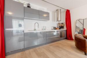 uma cozinha com um lavatório e uma cortina vermelha em Appartement spacieux à 15 minutes du jet d'eau em Genebra