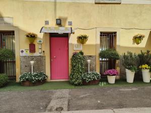 a building with a pink door and some potted plants at Giardino Giusti House & Court in Verona