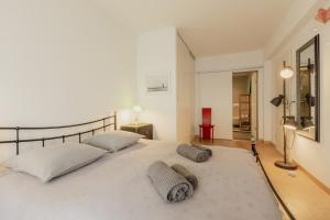 um quarto com uma grande cama branca e 2 almofadas em Appartement spacieux à 15 minutes du jet d'eau em Genebra