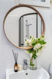 - un miroir rond au-dessus d'un lavabo dans la salle de bains dans l'établissement Székely Bertalan Residence, à Budapest