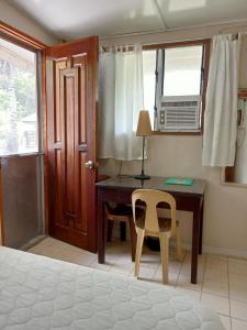 Schlafzimmer mit einem Schreibtisch, einem Stuhl und einem Fenster in der Unterkunft Villa 301 B&B in Baclayon
