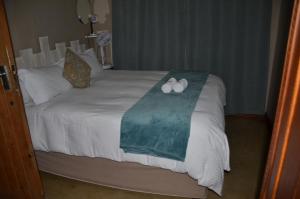 a bed with two rolled up towels on it at Stoep Cafe Guest House in Komatipoort