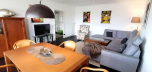 ein Wohnzimmer mit einem Sofa und einem Tisch in der Unterkunft App. "Syltliebe", Wohnung 6, 1 Etage in Westerland