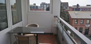 einen Balkon mit einem Tisch und 2 Fenstern in der Unterkunft App. "Syltliebe", Wohnung 6, 1 Etage in Westerland