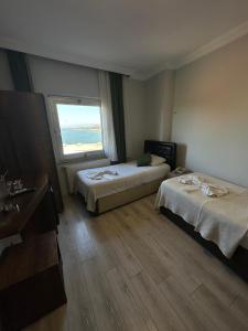 a hotel room with two beds and a window at Ganita Otel Trabzon in Trabzon