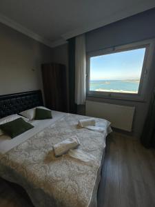 a hotel room with two beds and a large window at Ganita Otel Trabzon in Trabzon