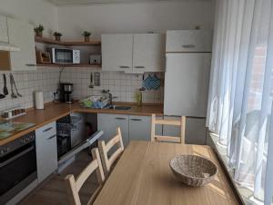 a kitchen with a wooden table and chairs and a table and a table at Ferienwohnung Amphora in Wunstorf