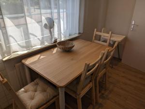 a wooden table and chairs in a room with a window at Ferienwohnung Amphora in Wunstorf