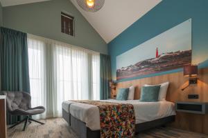 um quarto de hotel com uma cama e uma cadeira em Schierzicht Logement em Lauwersoog