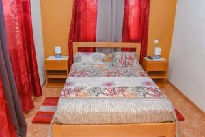 a bedroom with two beds and red curtains at Hot belvedere in Praia