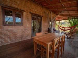Une table et des chaises en bois sont disponibles sur la terrasse. dans l'établissement 2 bedroom apartment with bay view, deck and roof terrace, à San Juan del Sur