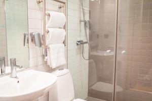 uma casa de banho com um chuveiro, um WC e um lavatório. em Gullmarsstrand Hotell & Konferens em Fiskebäckskil