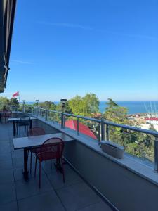 a balcony with tables and chairs and the ocean at Ganita Life Hotel in Trabzon