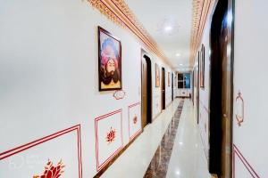 a hallway with white walls and paintings on the walls at Hotel Sahibs Royal Ville - Elegance by the Taj in Agra
