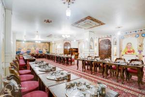 uma sala de jantar com mesas longas e cadeiras vermelhas em Hotel Sahibs Royal Ville - Elegance by the Taj em Agra