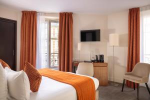 pokój hotelowy z łóżkiem z pomarańczowym kocem w obiekcie Hotel Elysées Bassano w Paryżu