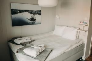 Una cama con toallas en una habitación en Gullmarsstrand Hotell & Konferens, en Fiskebäckskil
