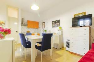 una cucina e una sala da pranzo con tavolo e sedie blu di [400 mt dal Mare] Villetta a Torre dell'Orso