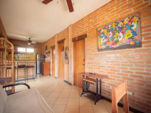 a room with a brick wall with a painting on the wall at 2 bedroom apartment with bay view, deck and roof terrace in San Juan del Sur