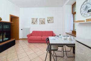 Una sala de estar con un sofá rojo y una mesa. en Appartamento Ania vista castello, en Tenno