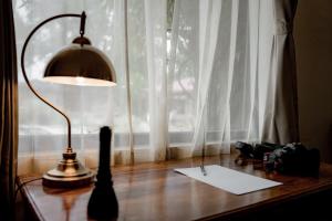una lámpara sentada en una mesa junto a una ventana en Aloof Jungle Lodge en Ghānerao