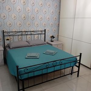 a bedroom with a bed with a blue comforter at Casa Irene in Catania