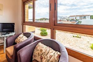 a living room with two chairs and a large window at Sant Carles 22 - apartamento con vistas al mar in Girona