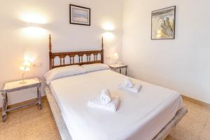 a bedroom with two beds with white sheets and two tables at Sant Carles 22 - apartamento con vistas al mar in Girona